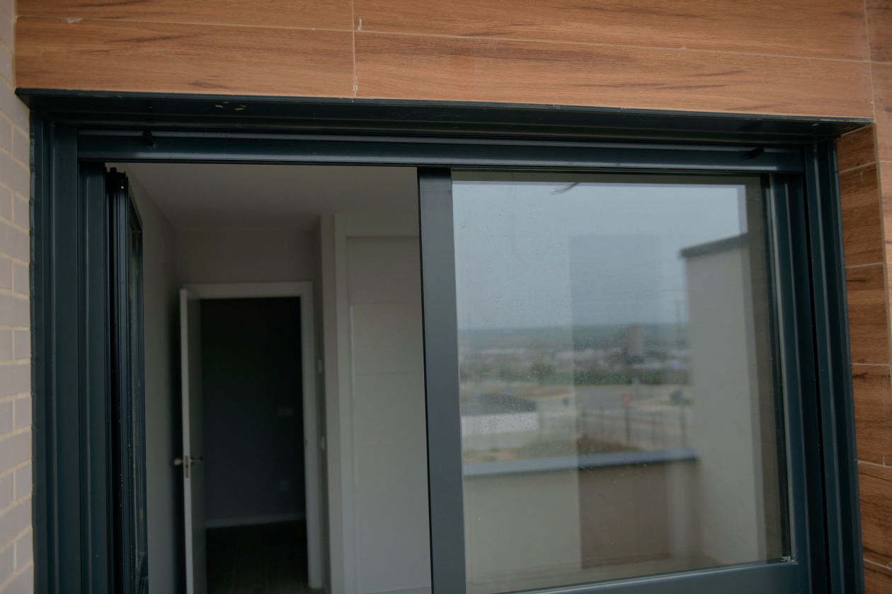 Corredera de aluminio con remates integrados en hueco de fachada